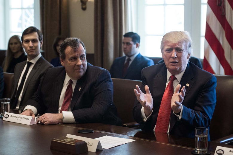 Jared Kushner, Chris Christie, and Donald Trump are all seated at a table in the White House. Kushner looks ahead, while Christie, sitting at the center of the table, looks at Trump, who is speaking.